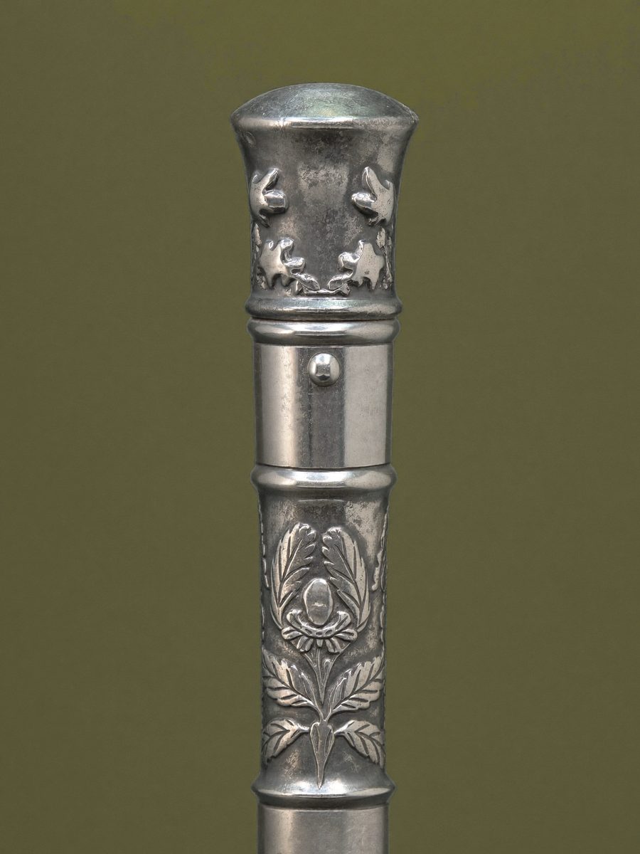 The engraved silver handle of a walking cane